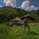 Cutting grass with a scythe at a Montenegro farm stay